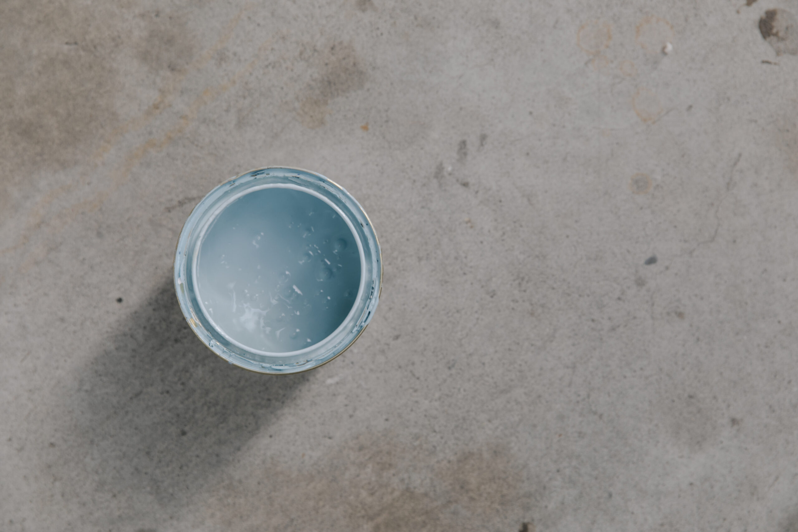 Baby blue tin open on concrete floor